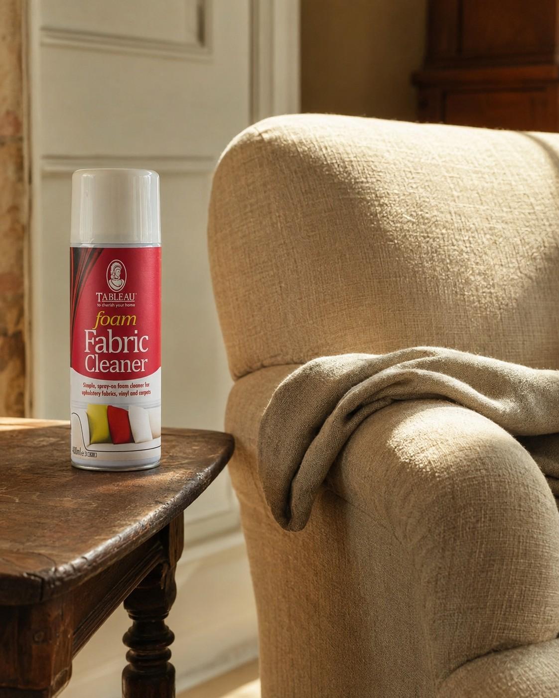 A can of Tableau Foam Fabric Cleaner on a side table beside a linen armchair