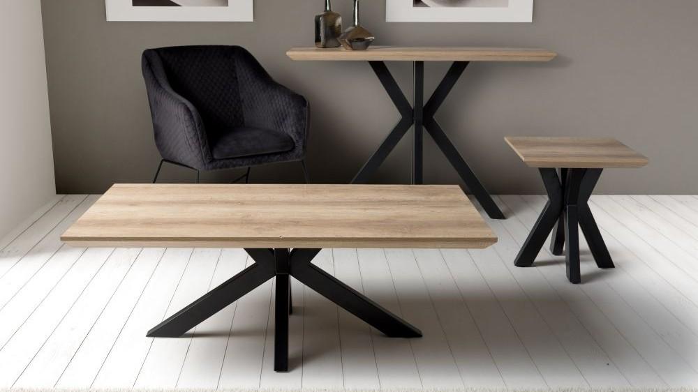 An oak-effect coffee table, console and lamp table with an armchair in a calm living room.