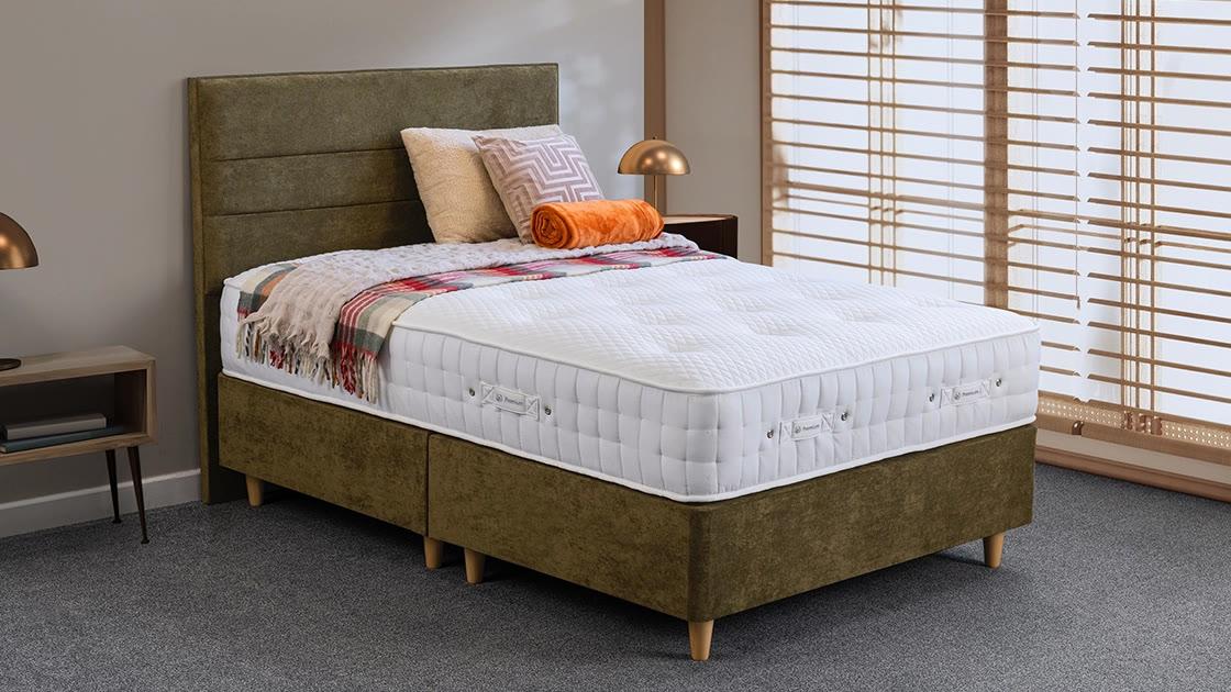 A Sweet Dreams Emerald 5000 divan with an olive velvet headboard, beside wooden blinds and a brass lamp