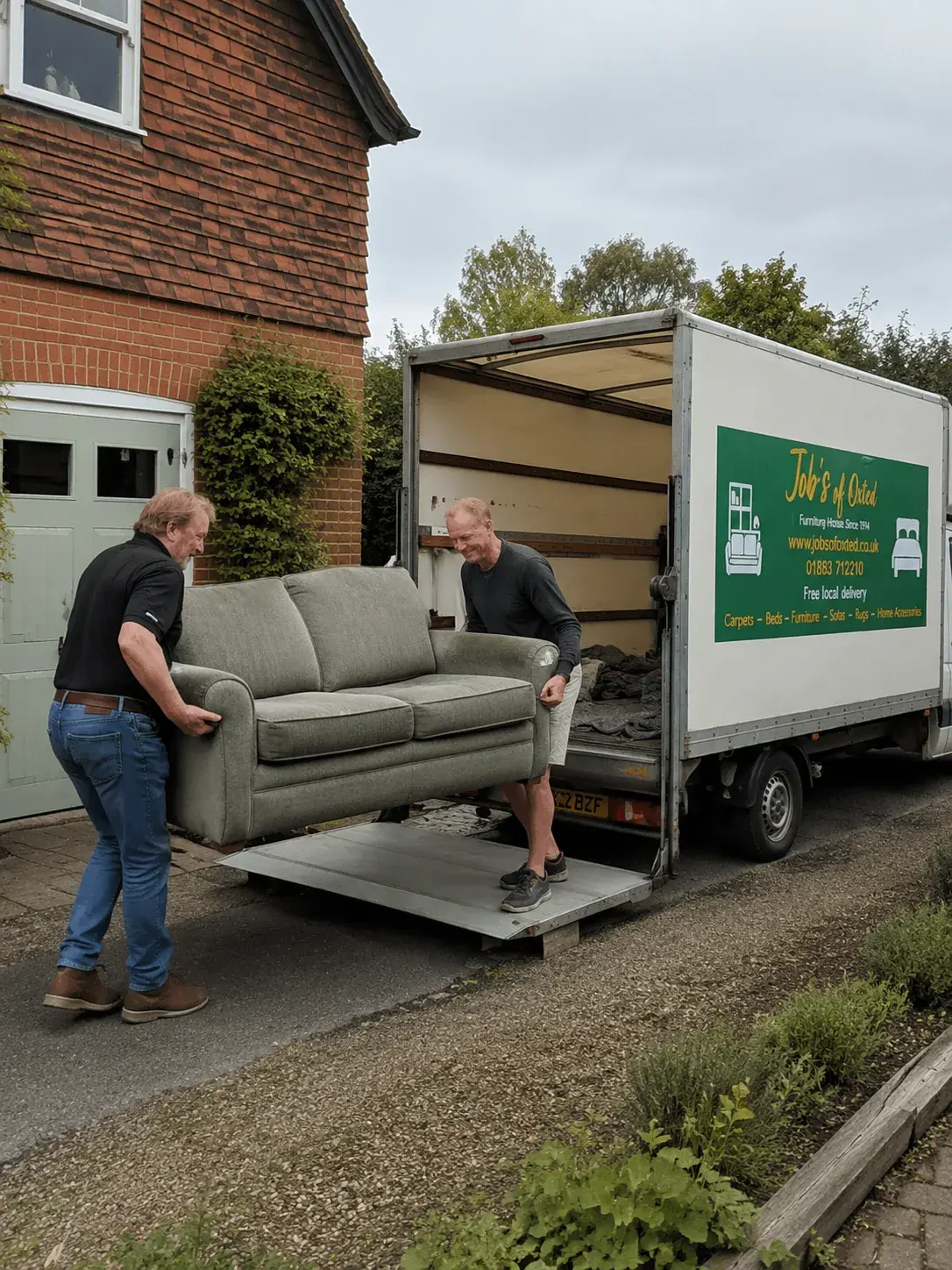 Two of the Job's of Oxted team carrying a sofa to the van for removal.