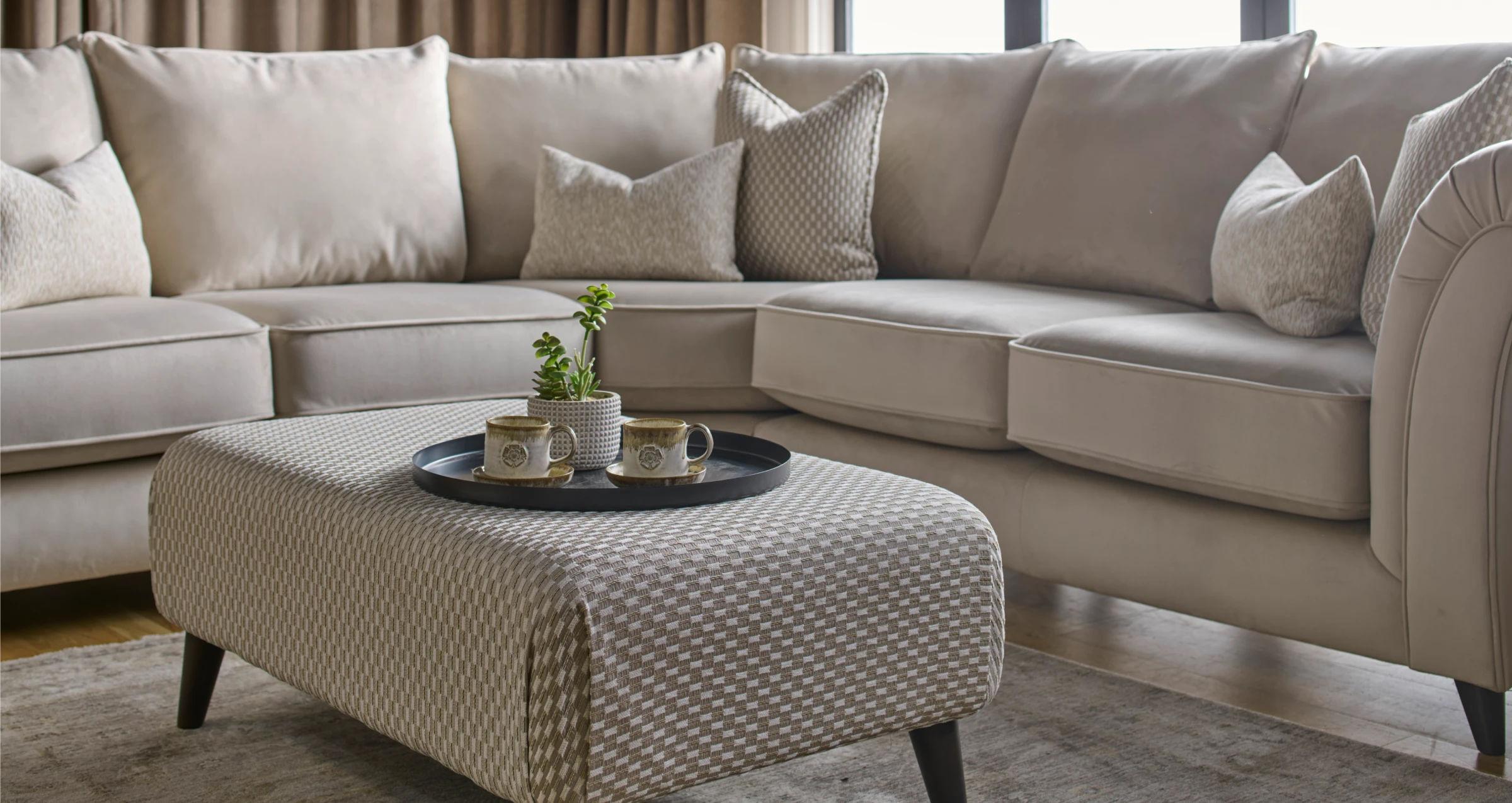 A cream Buoyant sofa dressed with soft cushions in a styled living room.