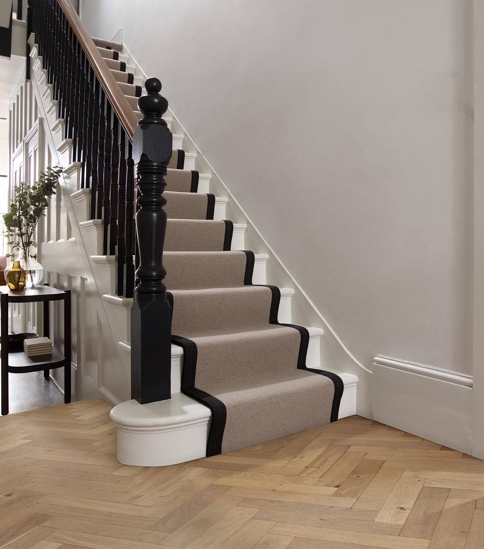 A Cormar wool carpet stair-runner with a bound border in a bright period hallway.