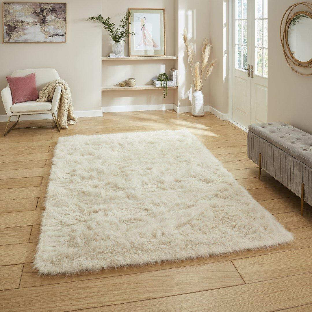 A soft cream wool-look rug grounding a warm, calm living room.