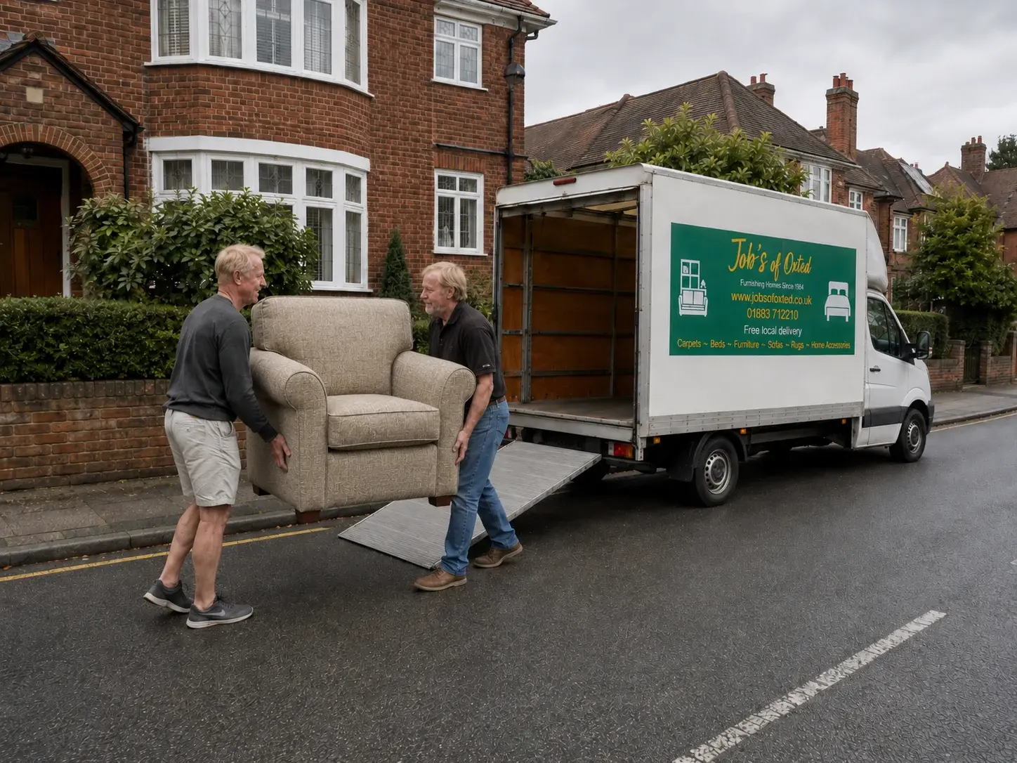 Two of our team carrying an old armchair out to the van for removal.